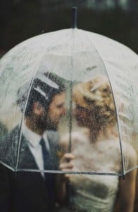 Bride and Groom in umbrella in the rain